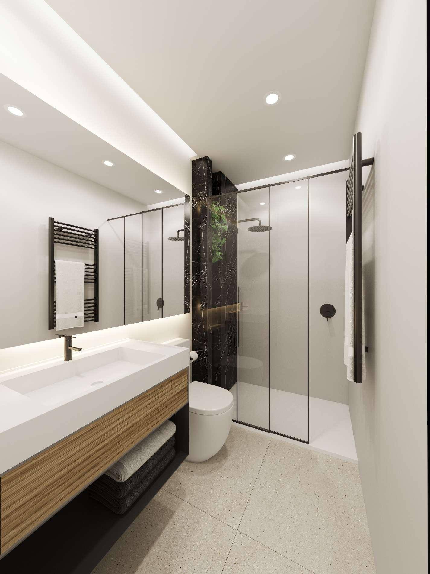 Elegantes Badezimmer mit begehbarer Dusche, Einzelwaschbecken und dunklem Marmorakzent.
