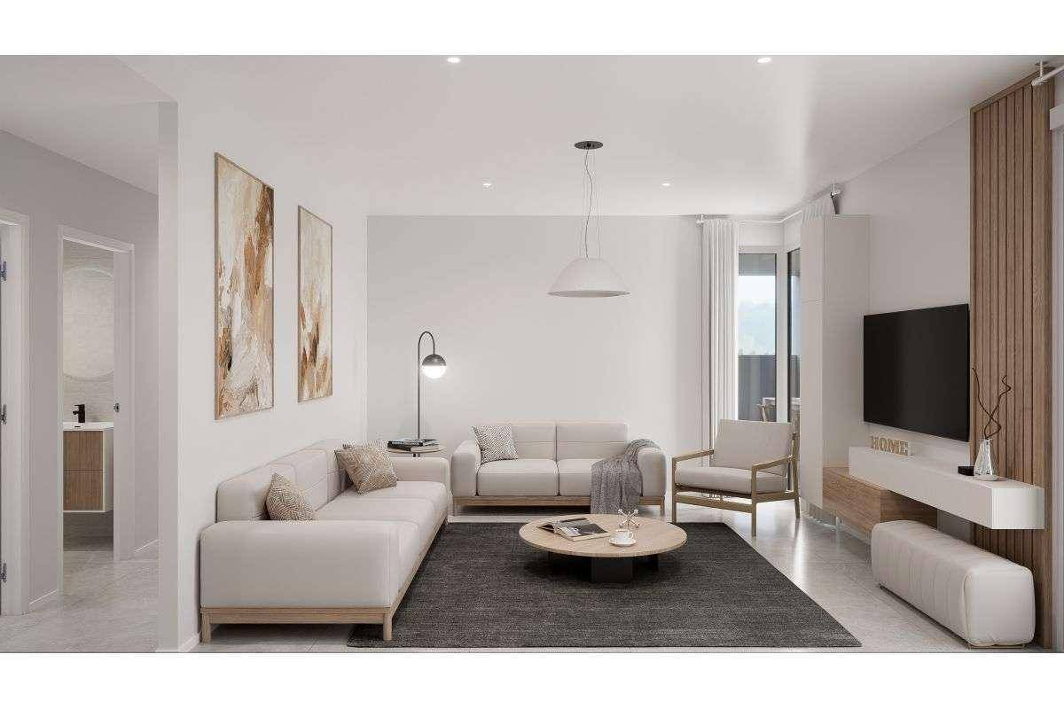 Geräumiges Wohnzimmer mit beigefarbenen Sofas, modernem Couchtisch und großem Fernseher.