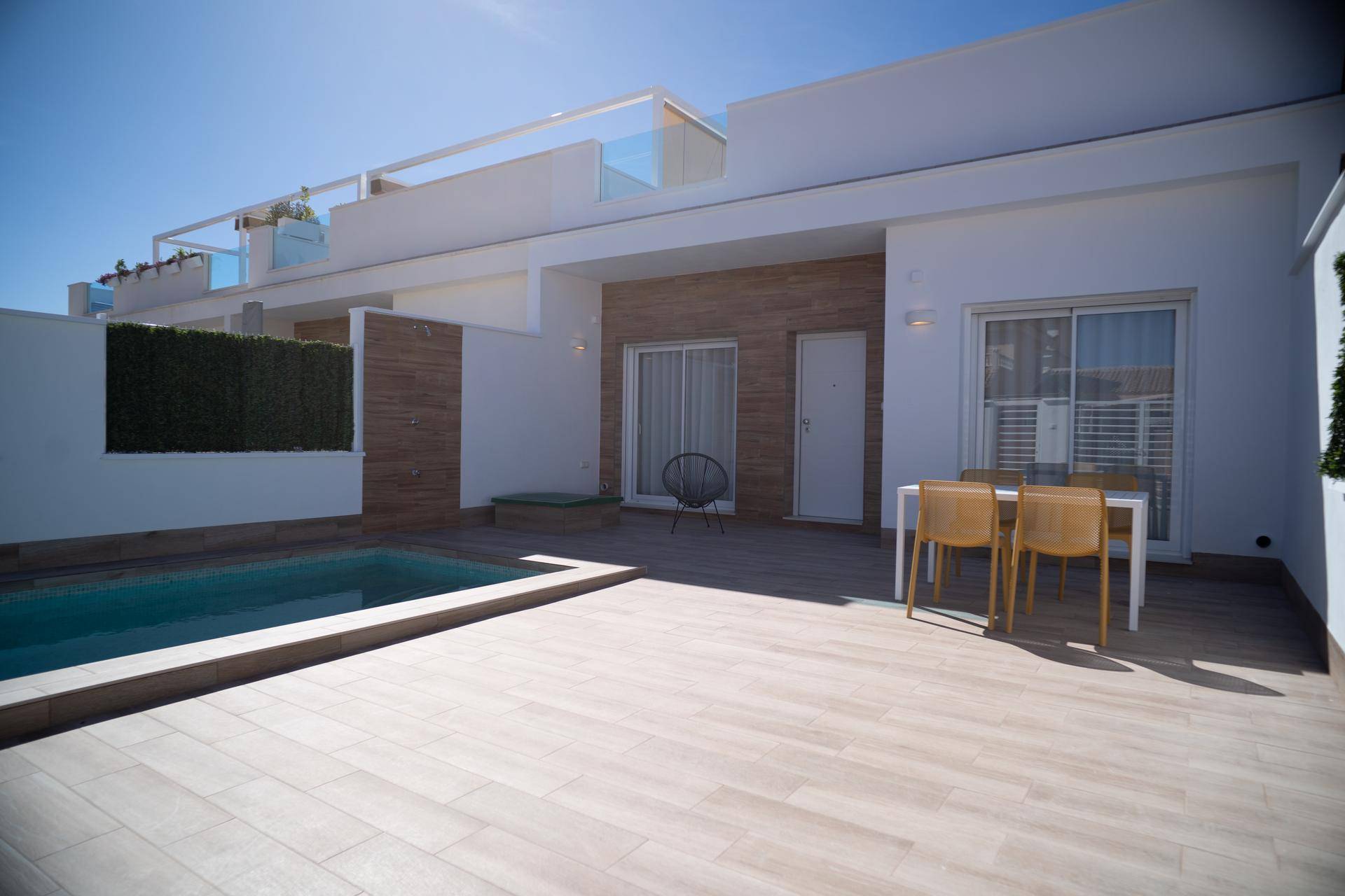 Geräumige Terrasse mit privatem Pool, Holzdeck und Essbereich im Freien.