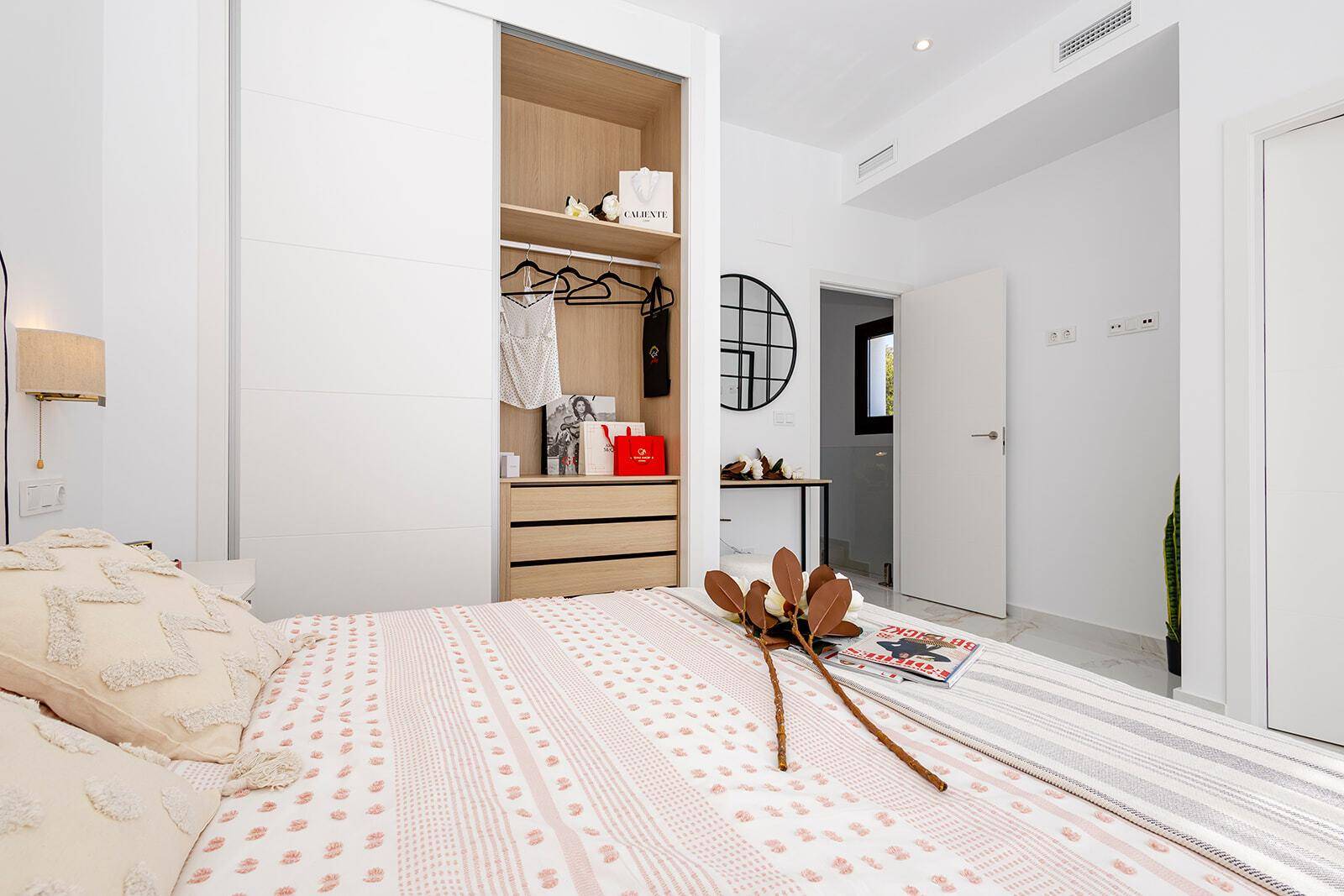 Modernes Schlafzimmer mit Einbauschrank, Doppelbett und stilvoller Dekoration.