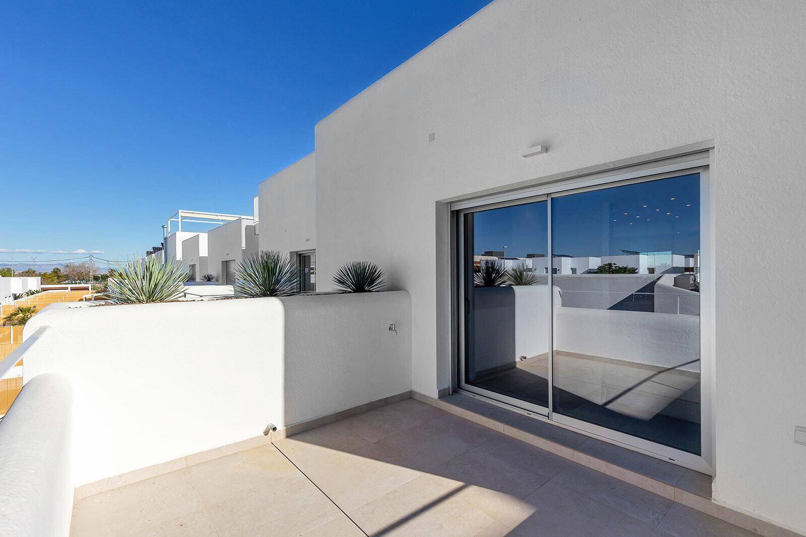 Heller Balkon mit Schiebetür und Blick auf die Umgebung, ideal für entspannte Stunden im Freien.