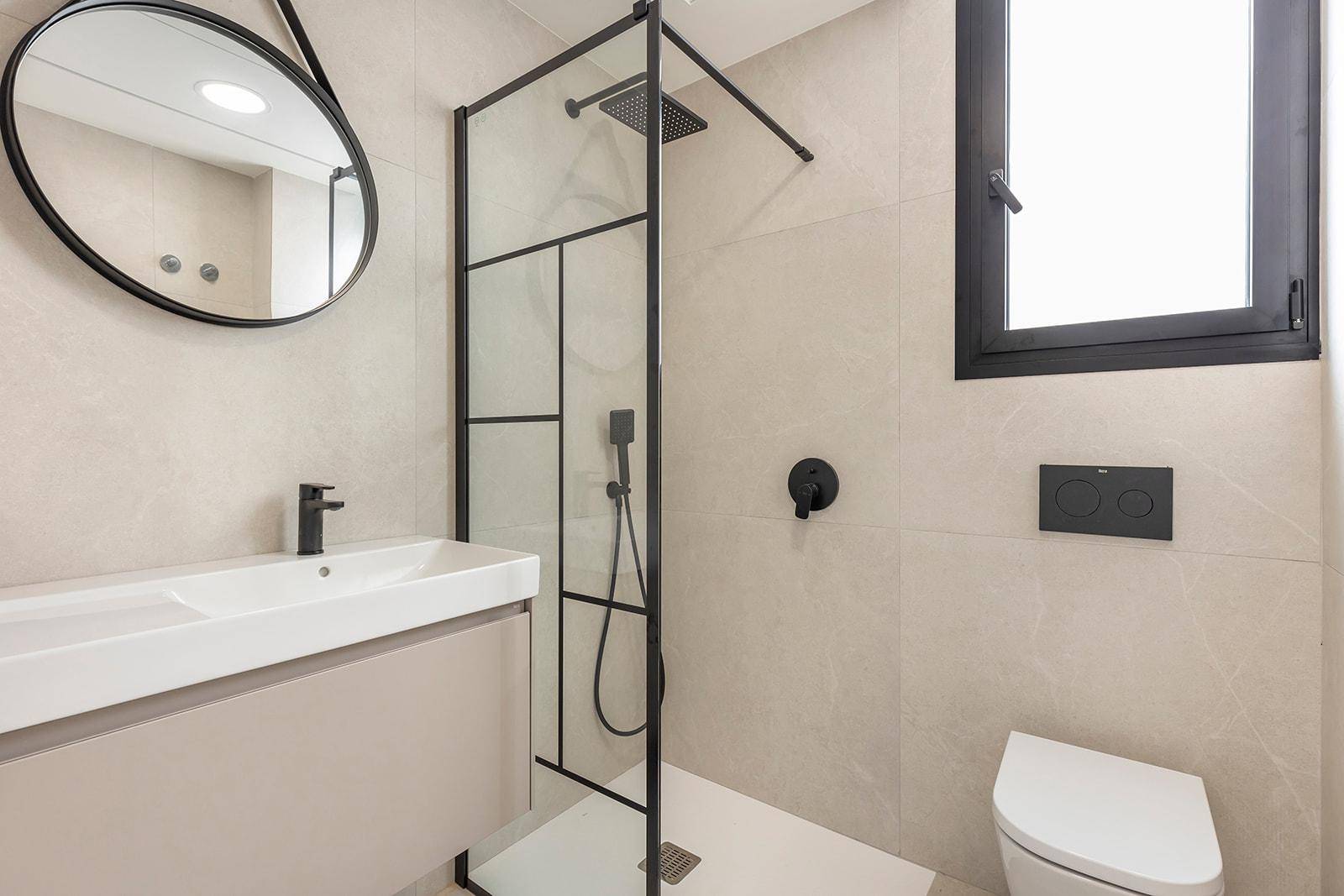 Modernes Badezimmer mit begehbarer Dusche, Wand-WC und eleganten schwarzen Armaturen.