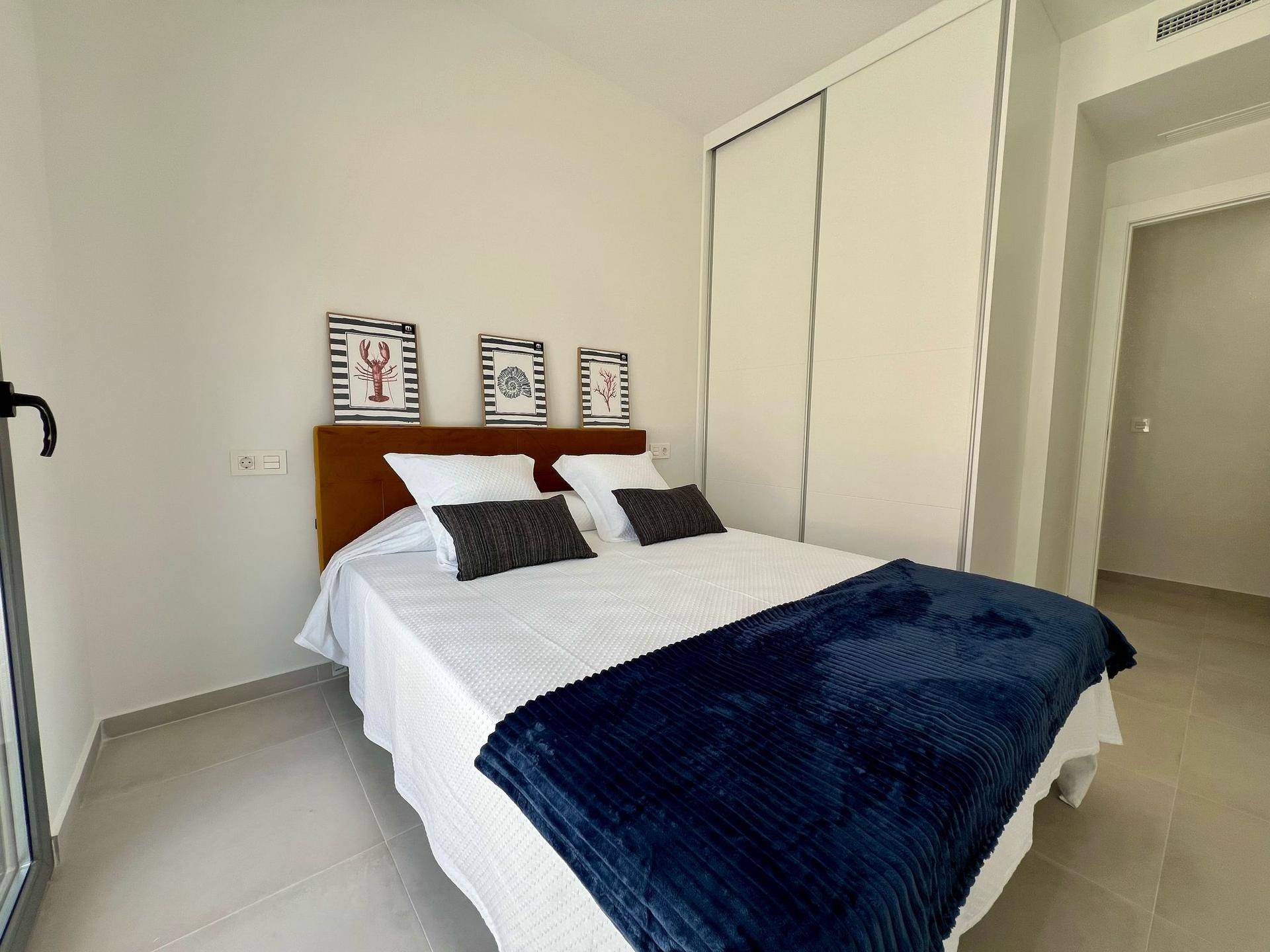 Gemütliches Schlafzimmer mit Einbauschränken, Doppelbett und Zugang zu einem Außenbereich.