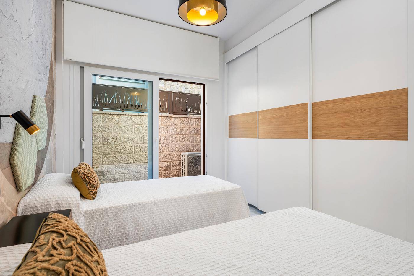 Gemütliches Schlafzimmer mit zwei Einzelbetten und modernem Einbauschrank, praktisch und stilvoll.
