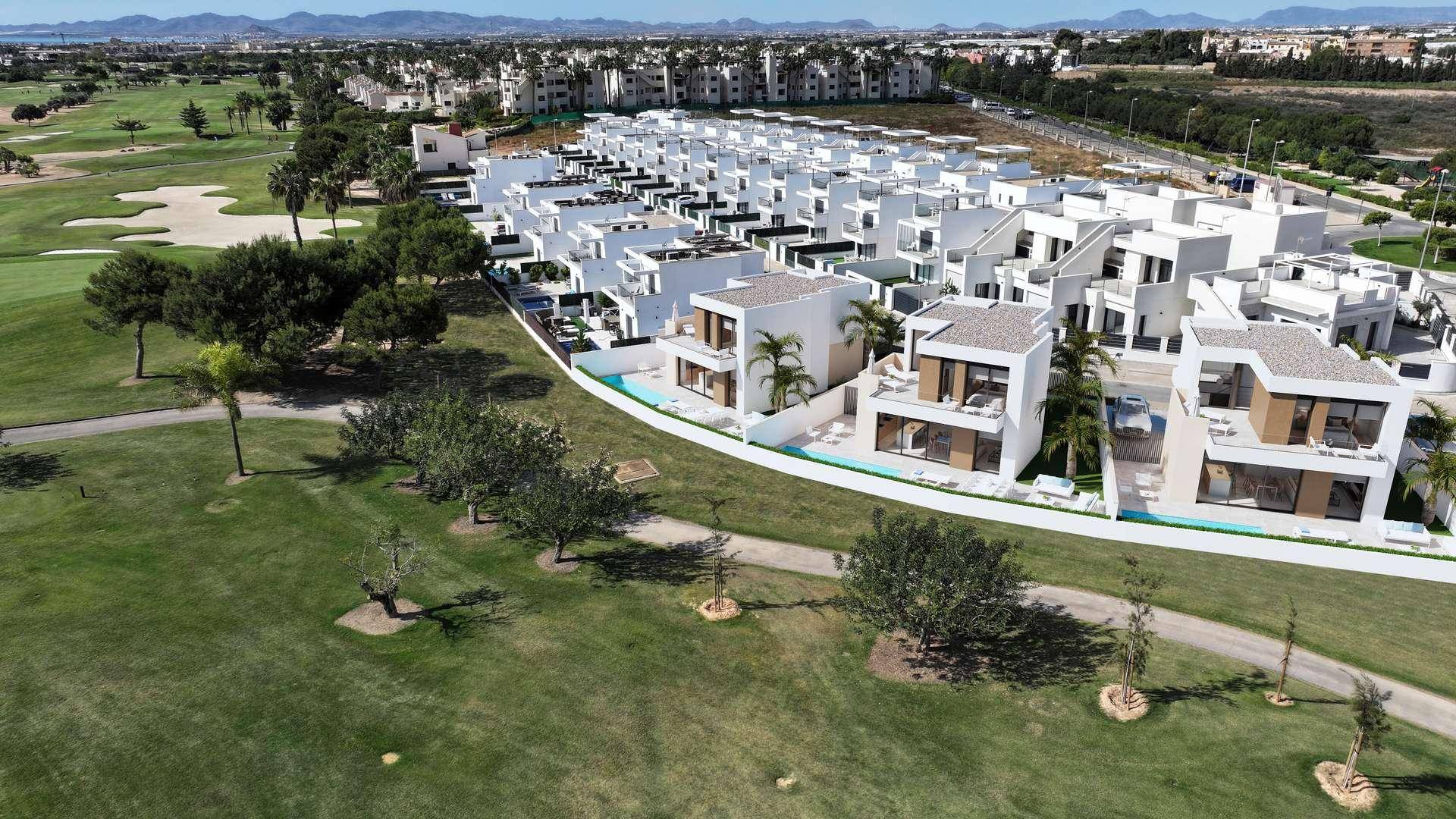 Panoramablick auf eine moderne Wohnsiedlung mit Villen und einem weitläufigen Golfplatz.