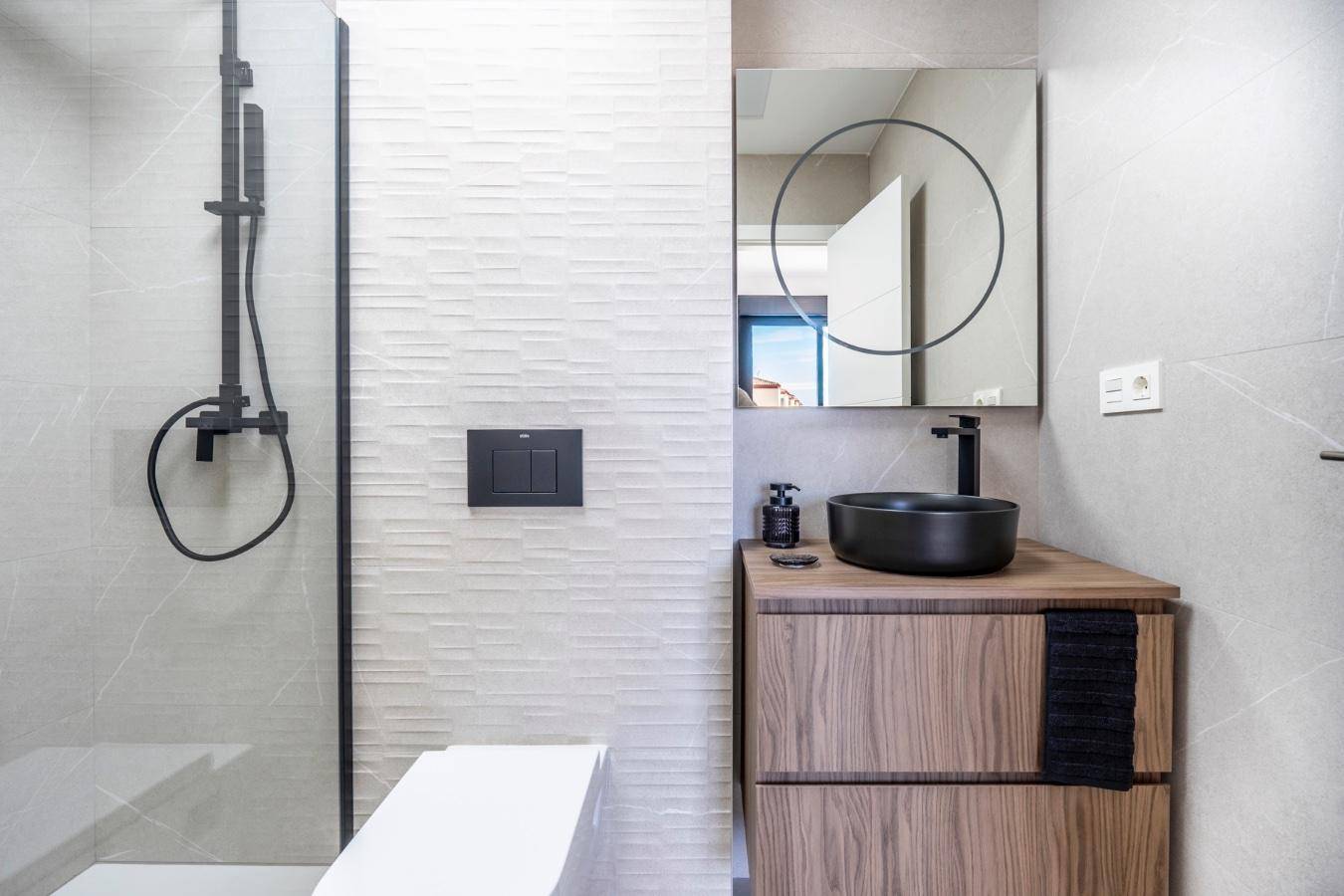 Modernes Badezimmer mit schwarzer Armatur, Holzwaschtisch, Aufsatzwaschbecken und begehbarer Dusche.