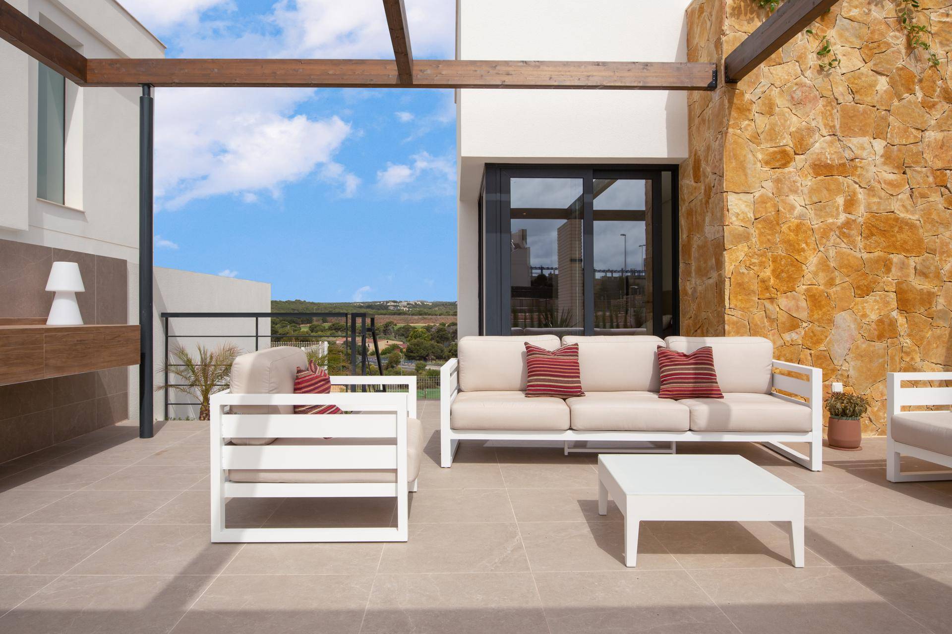 Stilvoller Lounge-Bereich auf der Terrasse mit bequemen Möbeln und weitem Blick in die Landschaft.