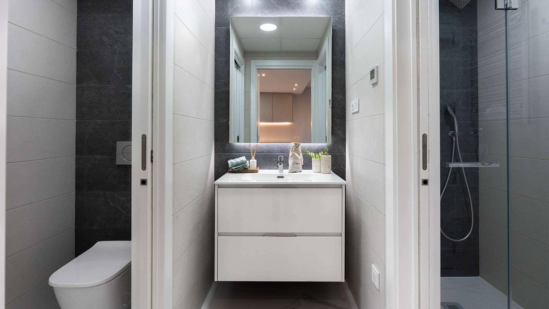 Modernes Badezimmer mit Waschtisch, wandhängendem WC und begehbarer Dusche in elegantem Design.