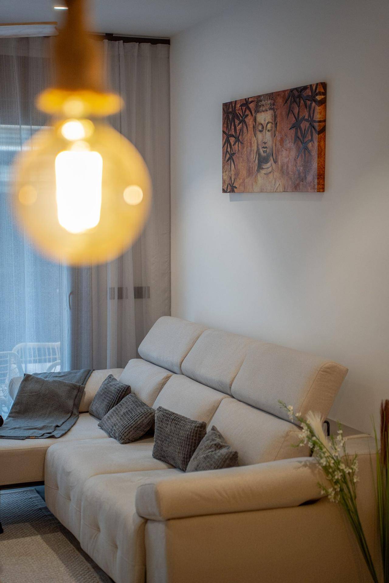 Helles Wohnzimmer mit bequemem Ecksofa, modernen Kissen und dekorativer Wandkunst.