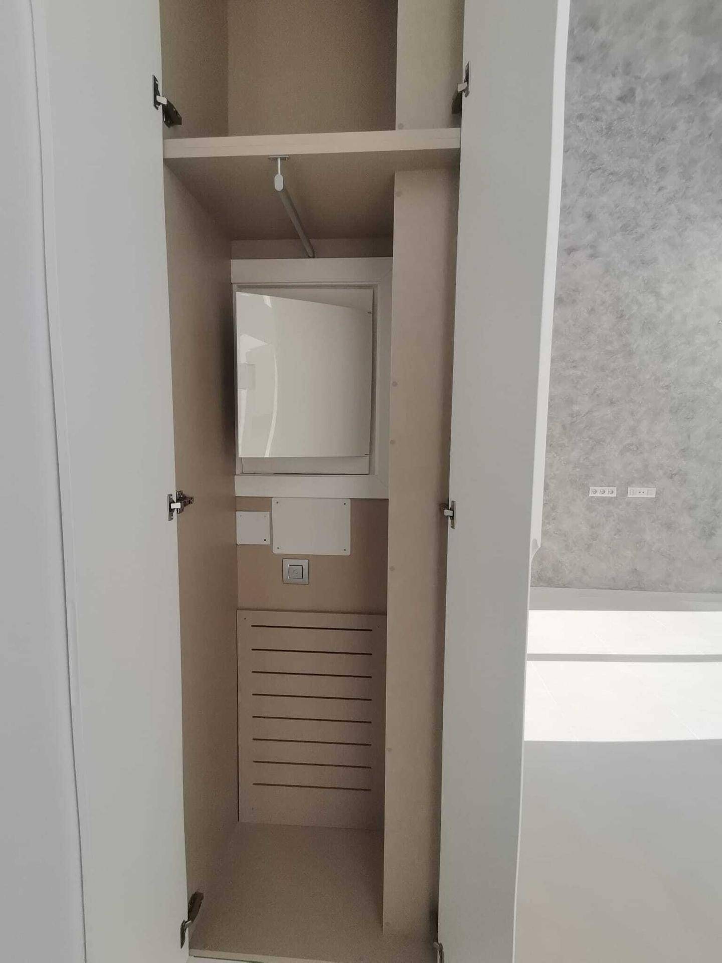 Praktischer Wandschrank für Haustechnik oder zusätzlichen Stauraum, gut organisiert und funktional.