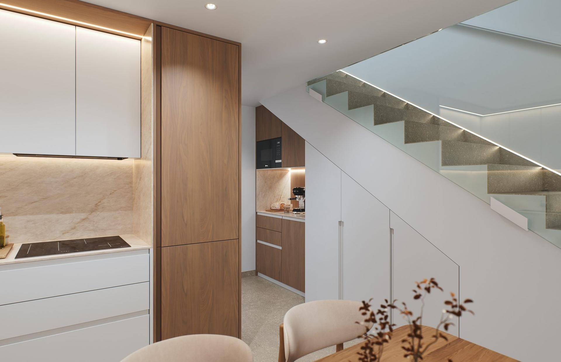 Detailansicht der modernen Küche mit integrierten Geräten und Stauraum unter der Treppe.