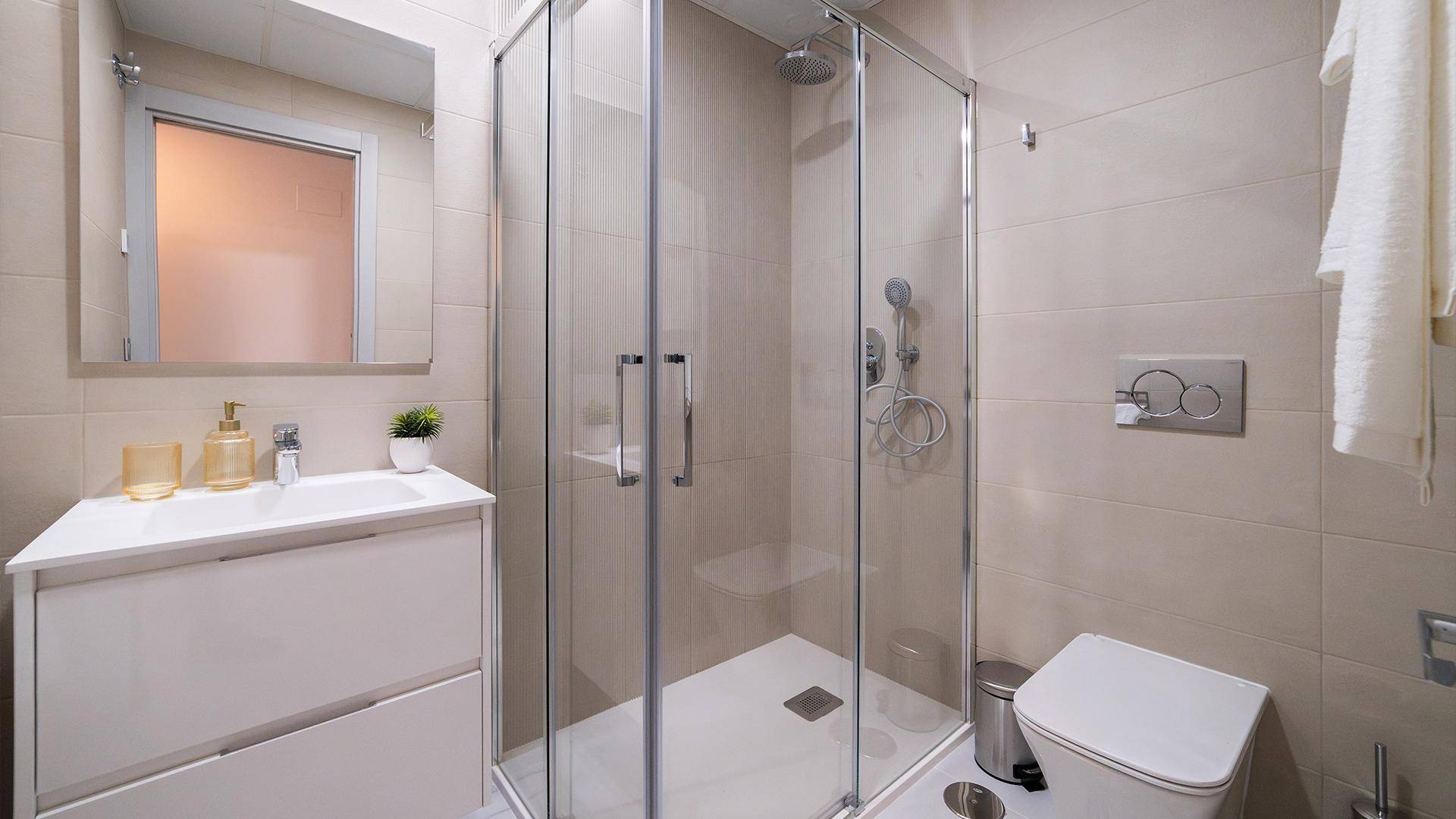 Modernes Badezimmer mit Duschkabine, Waschtisch und Wand-WC.