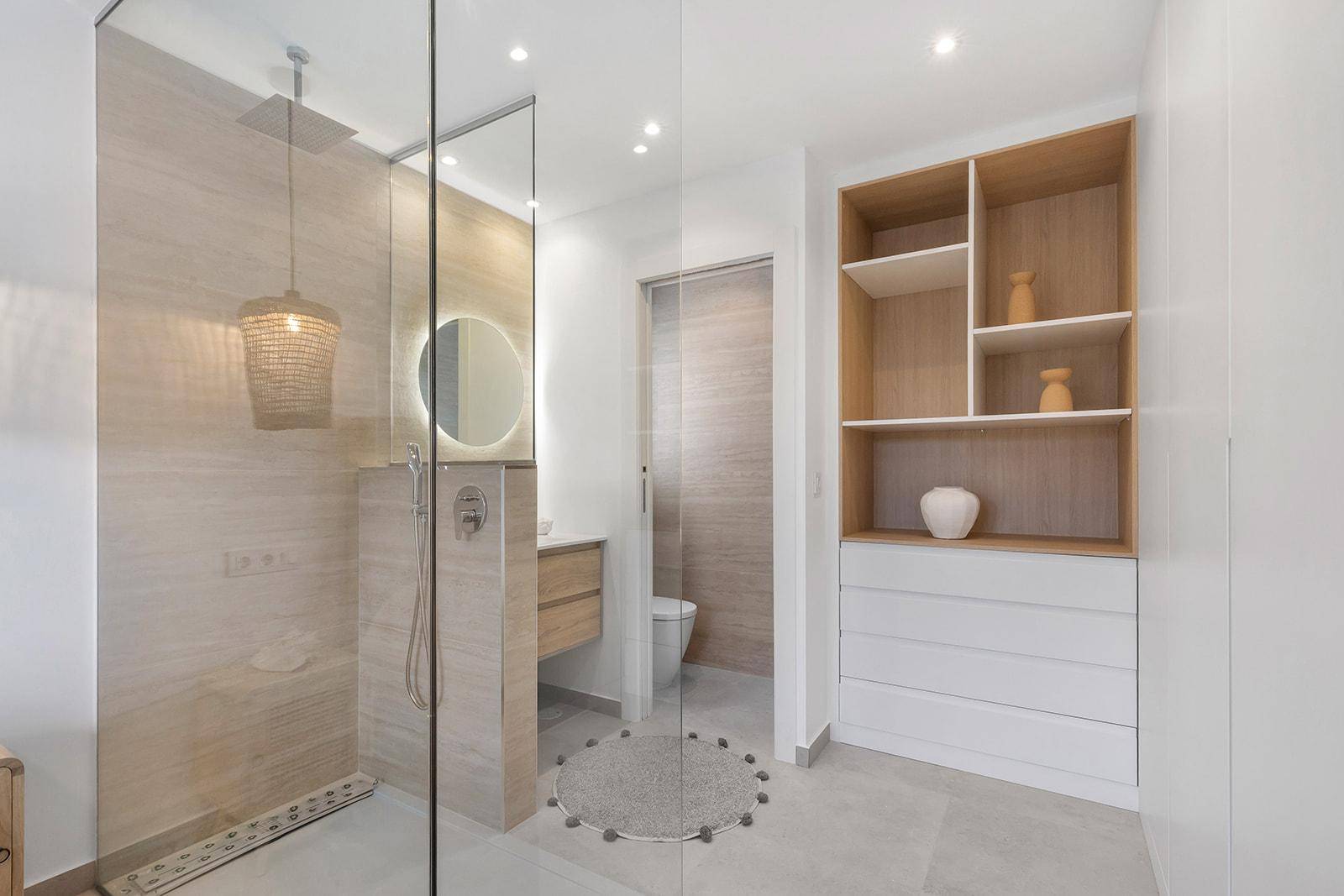 Modernes Badezimmer mit begehbarer Dusche, eleganten Fliesen und praktischen Regalen.