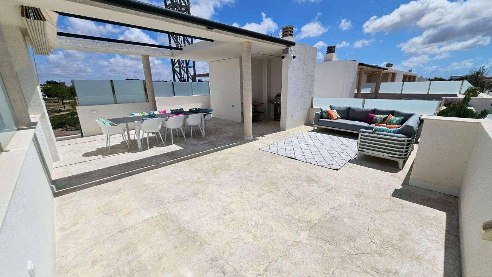Geräumige Dachterrasse mit Essbereich, Lounge-Möbeln und weitem Blick unter blauem Himmel.