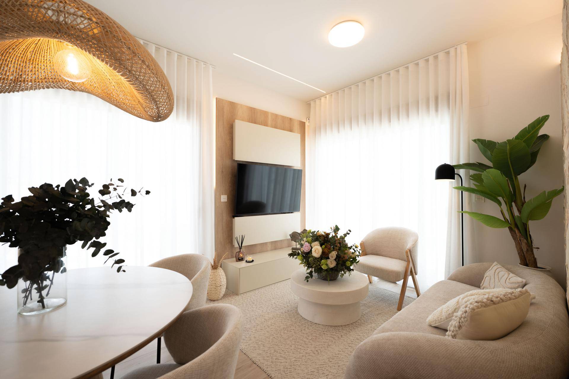 Gemütliches Wohnzimmer mit bequemer Couch, stilvoller Dekoration und großen Fenstern.