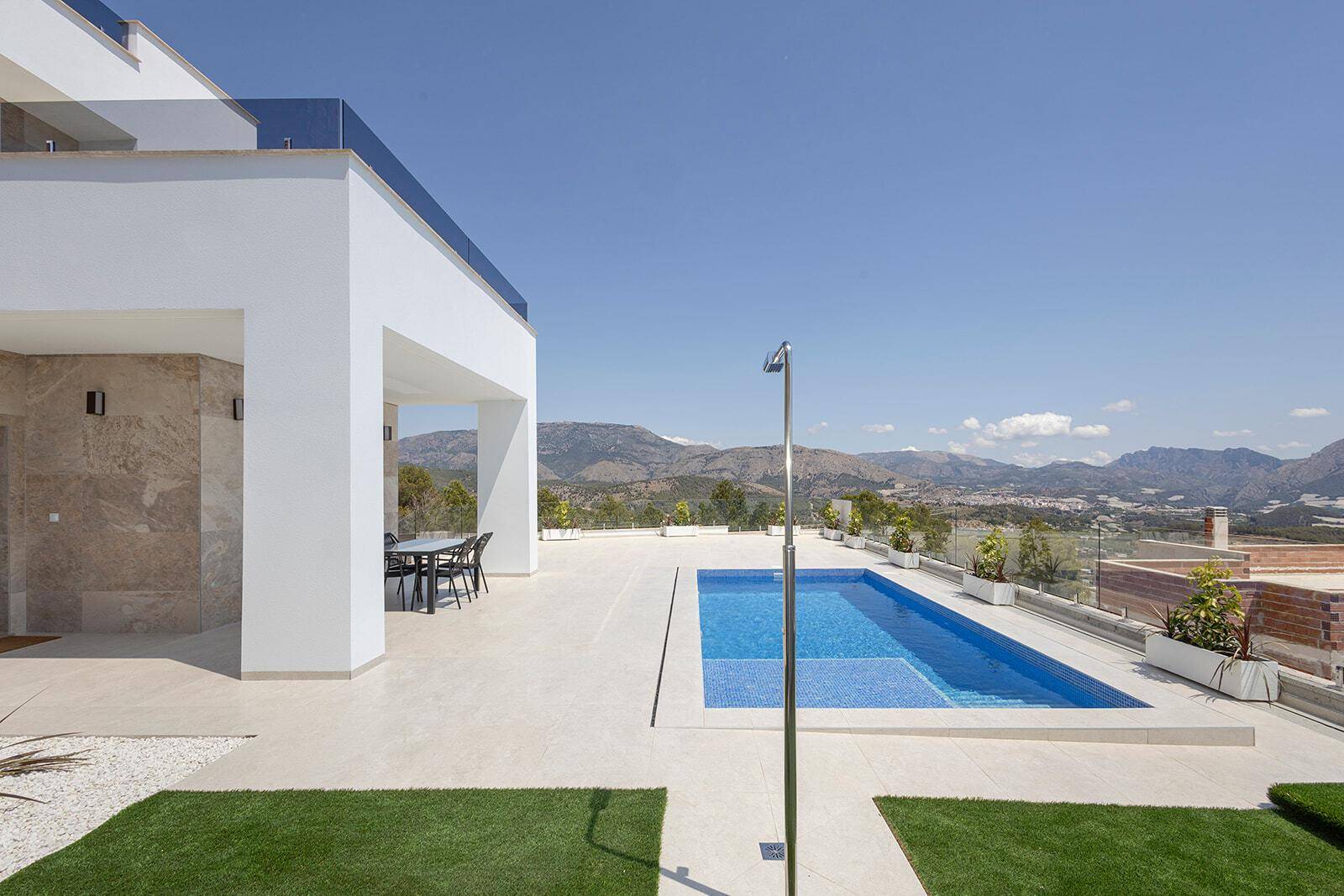 Weitläufige Terrasse mit Pool, Außendusche und Panoramablick auf die Berge und das Tal.
