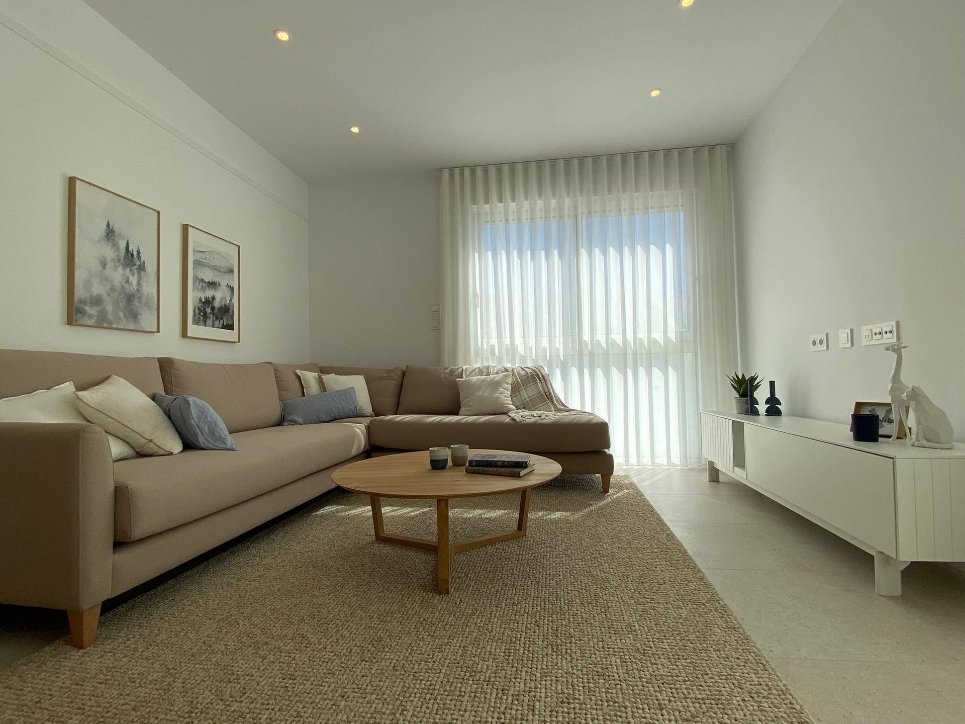 Helles Wohnzimmer mit großem Ecksofa, Couchtisch und moderner Dekoration.