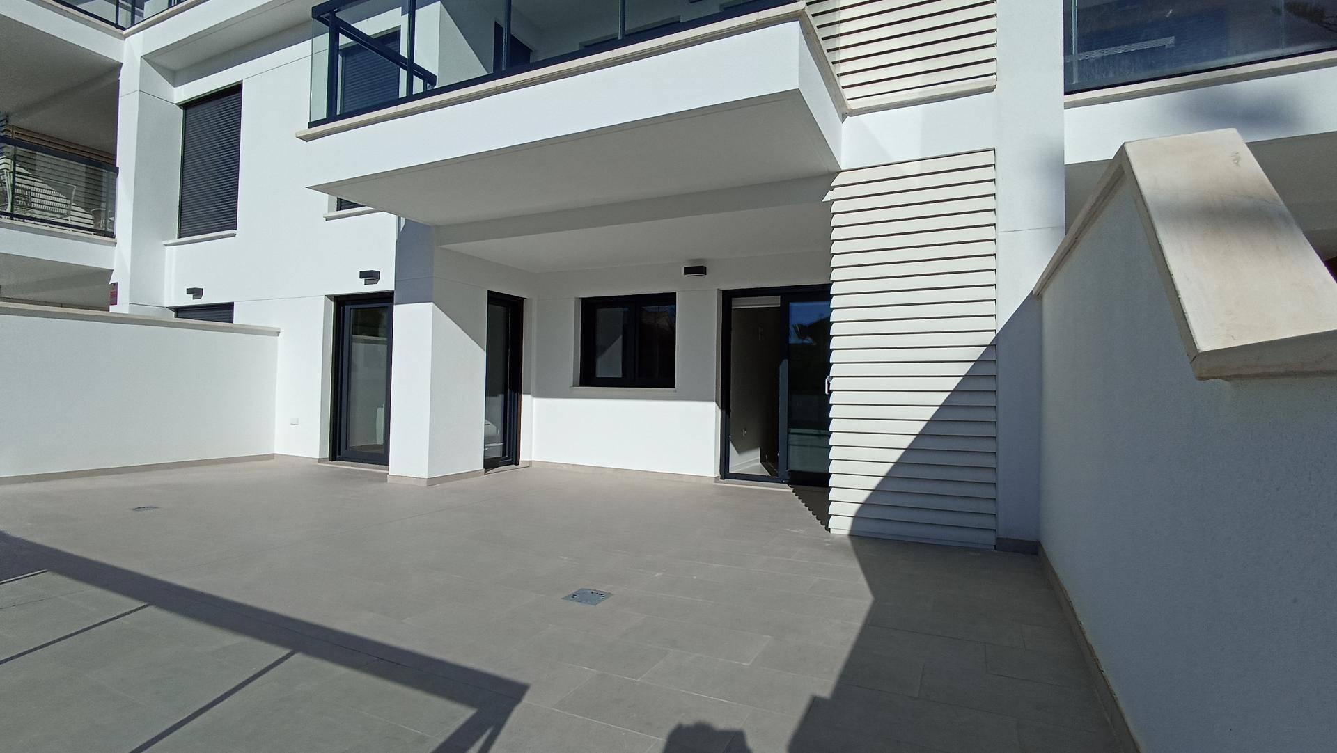 Geräumige, geflieste Terrasse im Erdgeschoss mit direktem Zugang zum Gebäude.