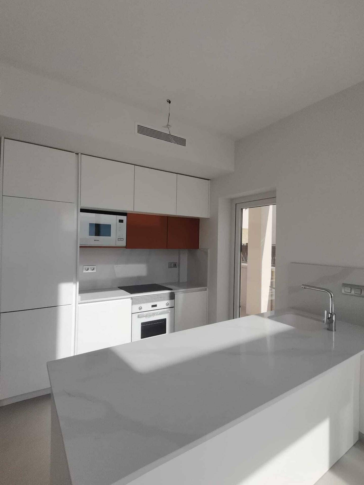 Moderne Einbauküche mit weißen Schränken, Kochfeld und Backofen, bereit zur Nutzung.