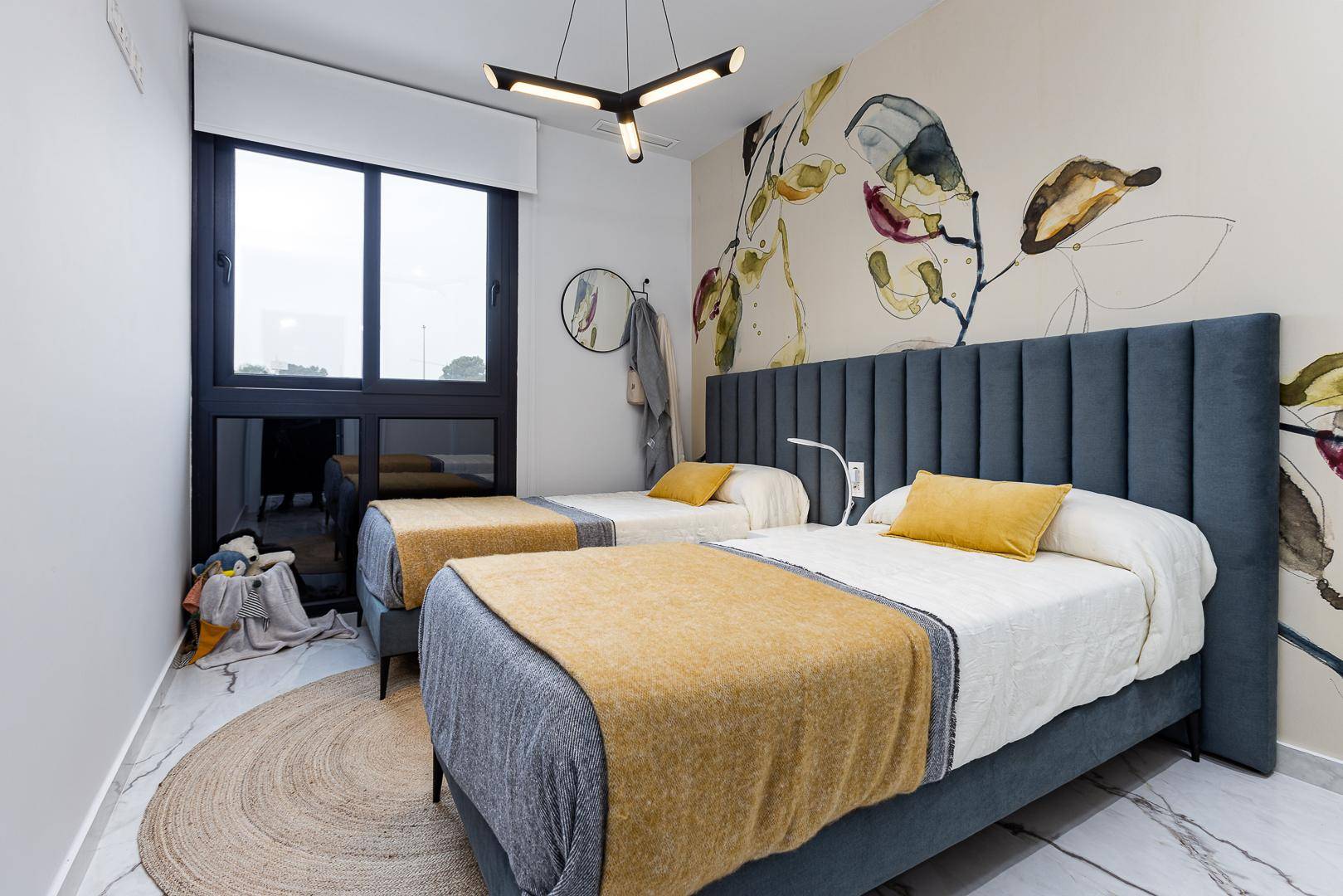 Geräumiges Schlafzimmer mit zwei Einzelbetten, Fenster und stilvoller Wandgestaltung.