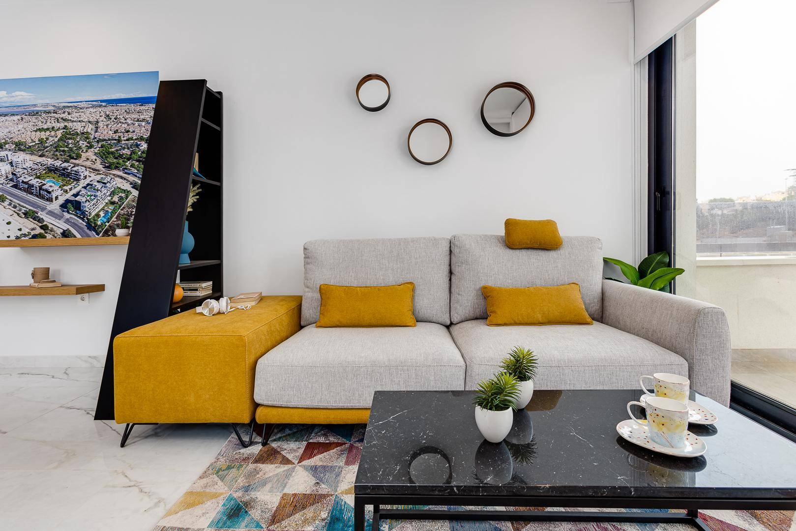 Gemütlicher Wohnbereich mit modernem Sofa, stilvollen Dekorationen und viel Tageslicht.