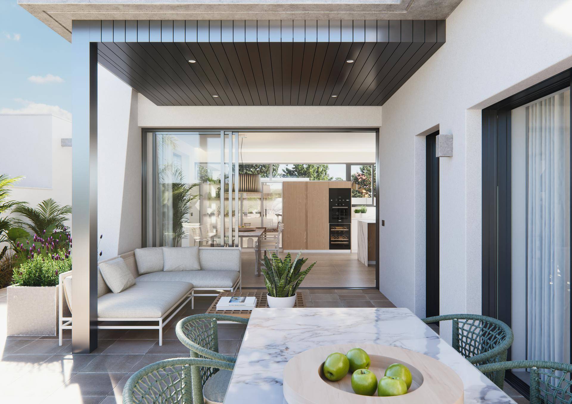 Überdachte Terrasse mit Lounge- und Essbereich, mit Blick auf den hellen Innenraum.
