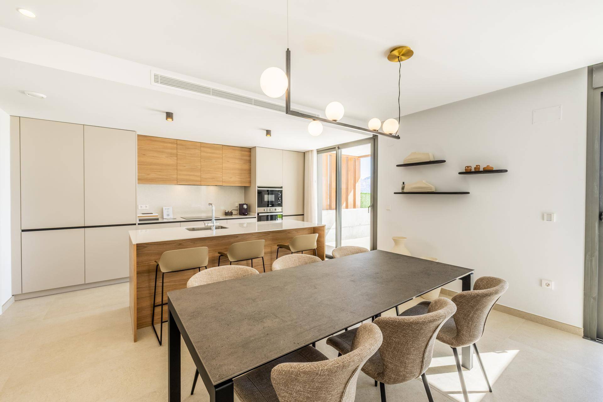 Moderne Küche mit Holz- und Beigefarbenen Fronten, Kochinsel und großem Esstisch.