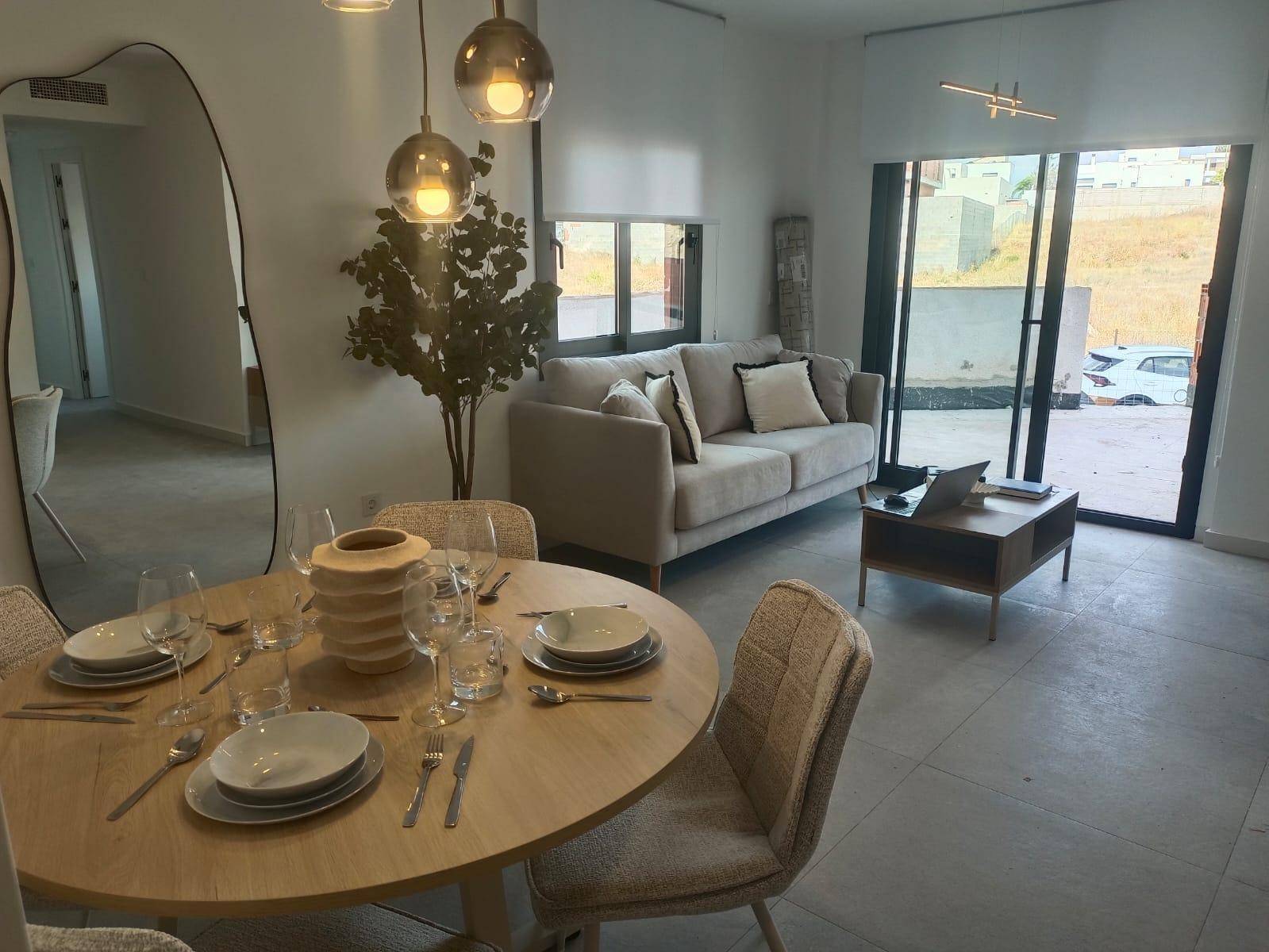 Gemütlicher Wohn-Essbereich mit Holztisch, bequemer Couch und Zugang zur Terrasse.