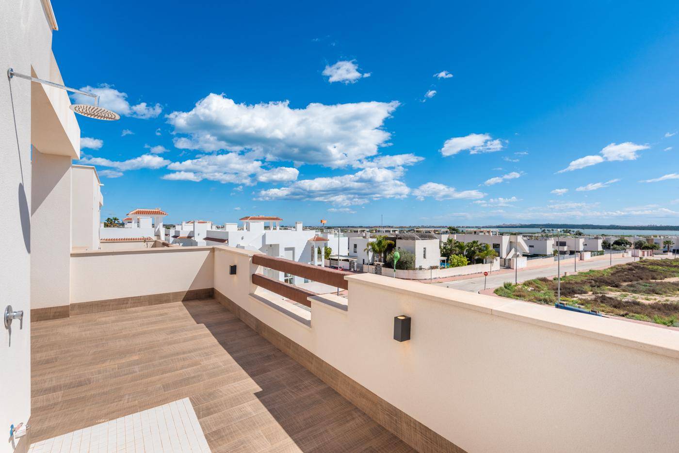 Geräumige Dachterrasse mit Außendusche und weitem Blick auf die Umgebung und das Meer.