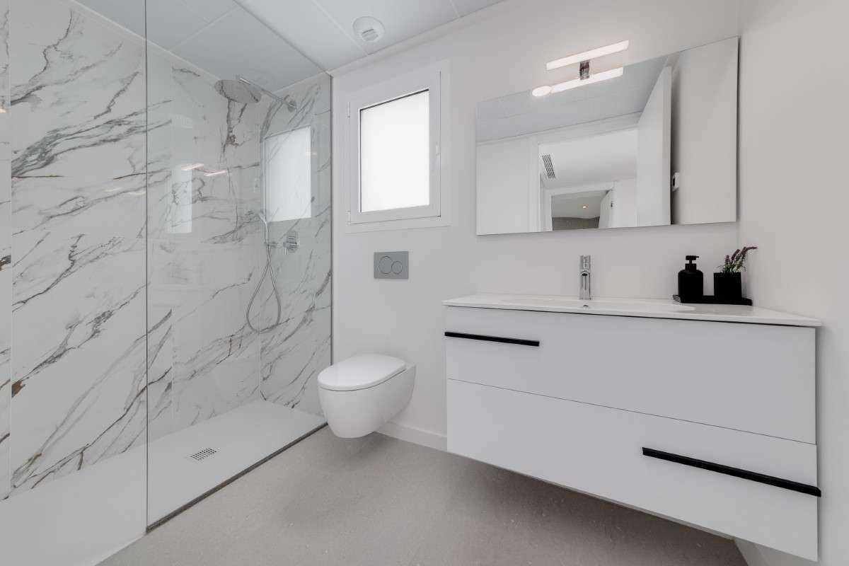 Modernes Badezimmer mit großer begehbarer Dusche, Wand-WC und schwebendem Waschtisch.
