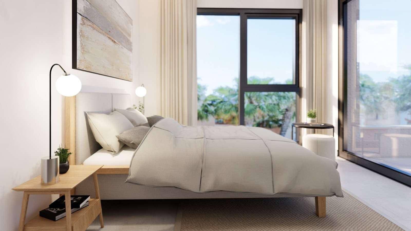 Modernes Schlafzimmer mit großem Fenster, das einen Blick auf Palmen und viel Tageslicht bietet.