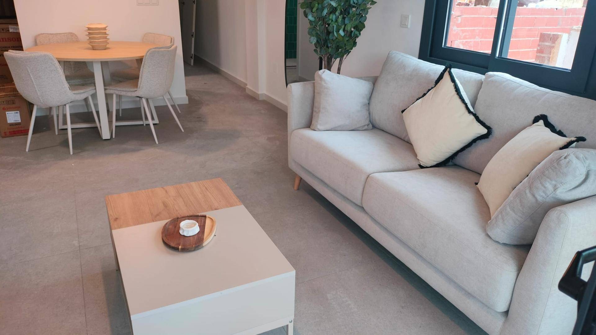 Moderner Wohnbereich mit beigem Sofa, Couchtisch und Blick auf den Essbereich.