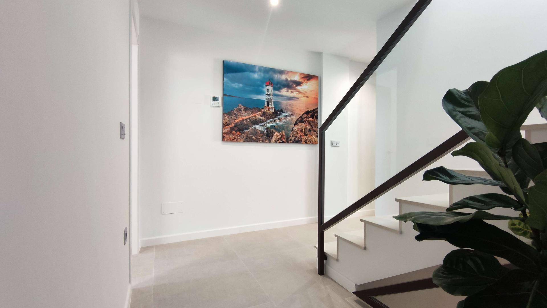 Heller Treppenabsatz mit Kunstwerk an der Wand und Blick auf die Treppe.