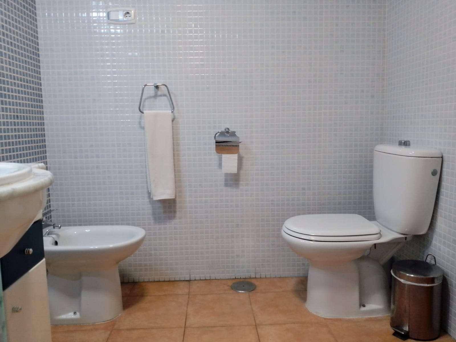 Badezimmer mit WC, Bidet und hellen Mosaikfliesen, bietet grundlegende Ausstattung.