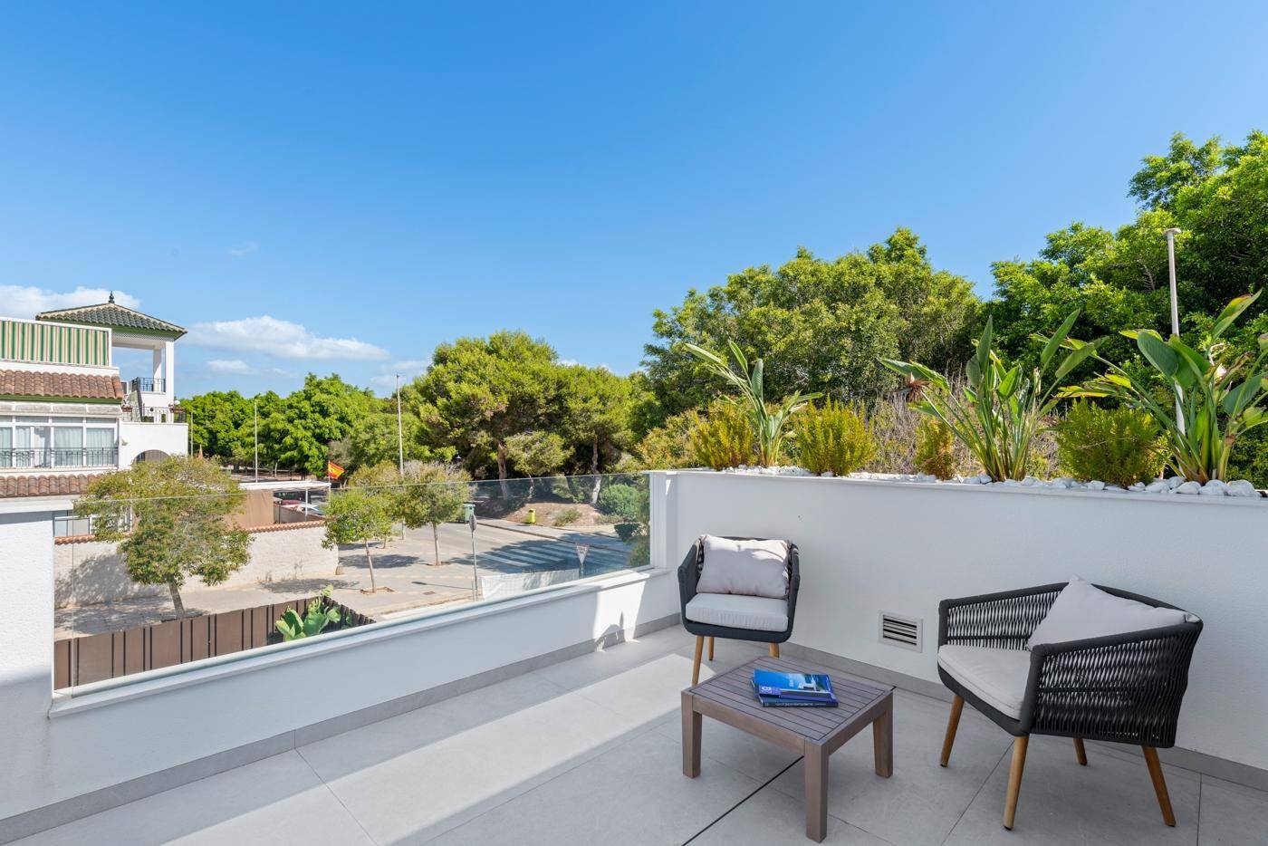 Möblierter Balkon mit Sitzgelegenheiten und Pflanzen, bietet einen Blick auf die Straße.