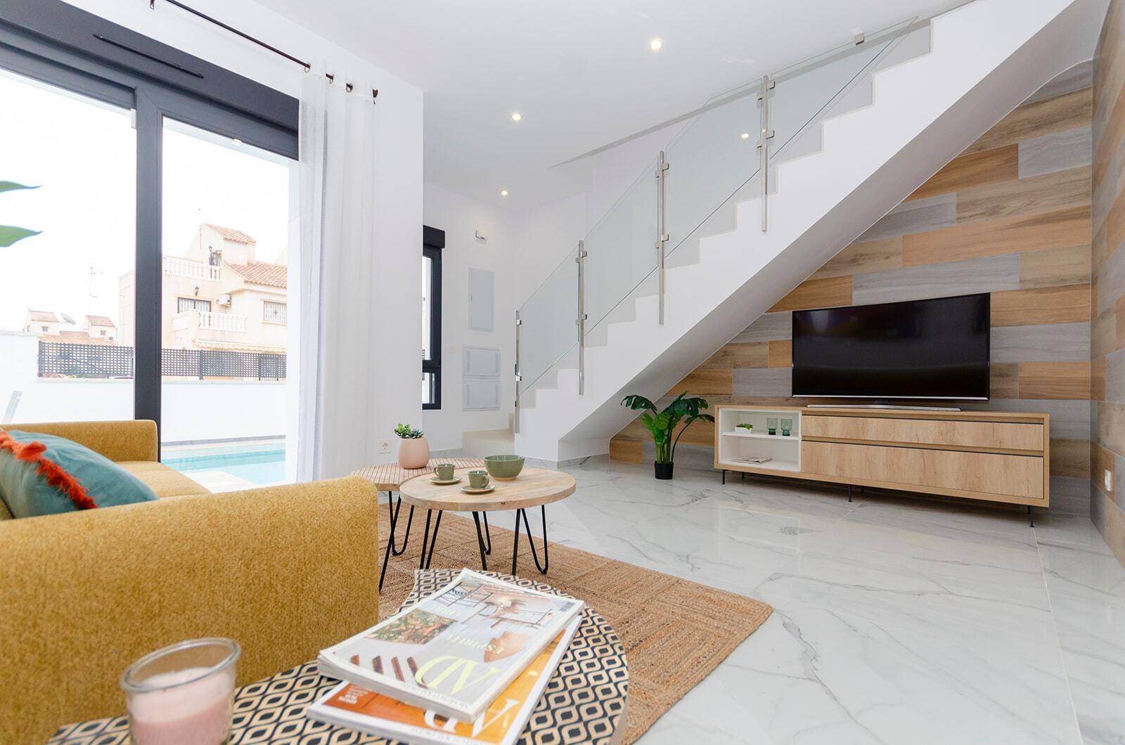 Gemütlicher Wohnbereich mit Sofa, Couchtisch und Treppe zum Obergeschoss.