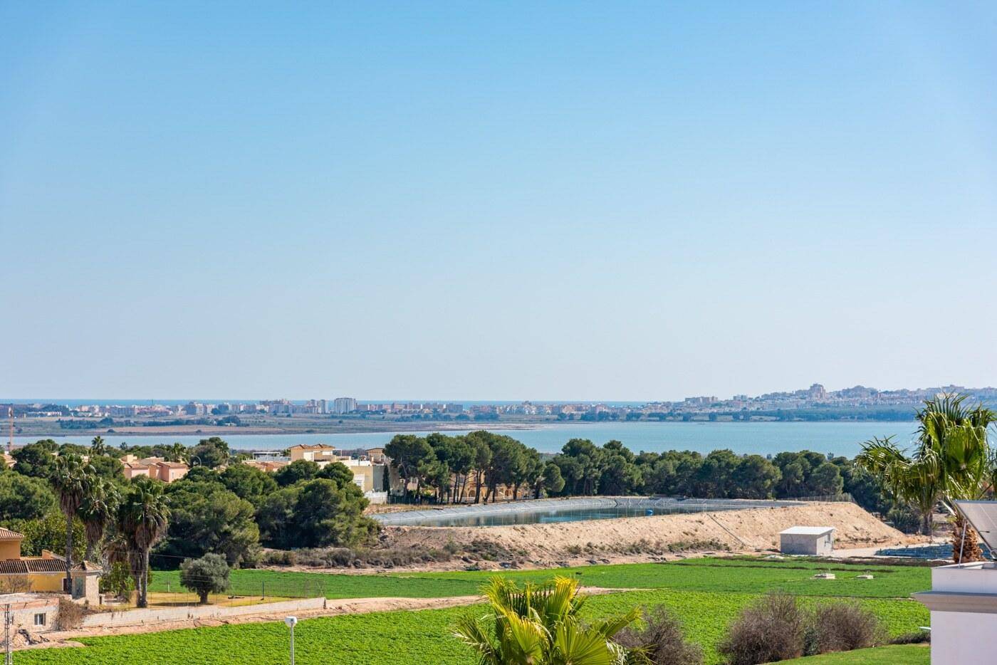 Panoramablick auf das Meer, die Küstenlinie und die umliegende grüne Landschaft.