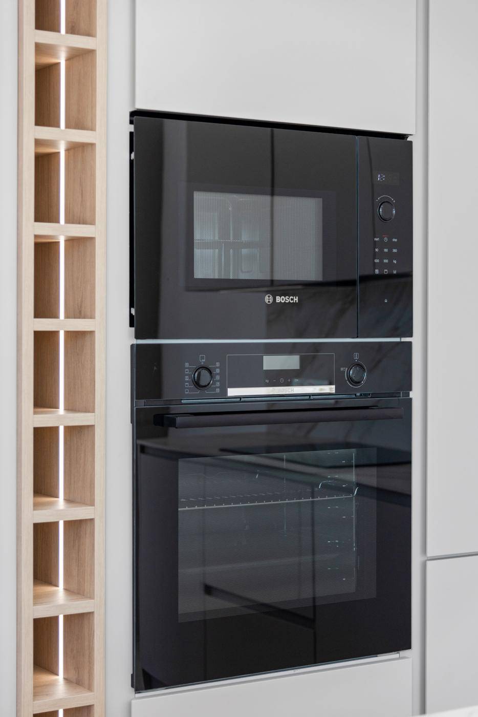 Integrierte Küchengeräte von Bosch, darunter Backofen und Mikrowelle, in moderner Einbauküche.