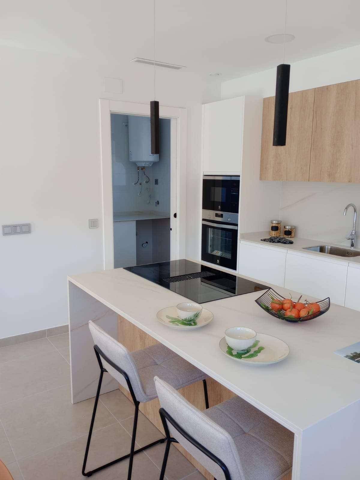 Moderne Küche mit Kochinsel, Induktionskochfeld und integrierten Geräten in hellem Design.