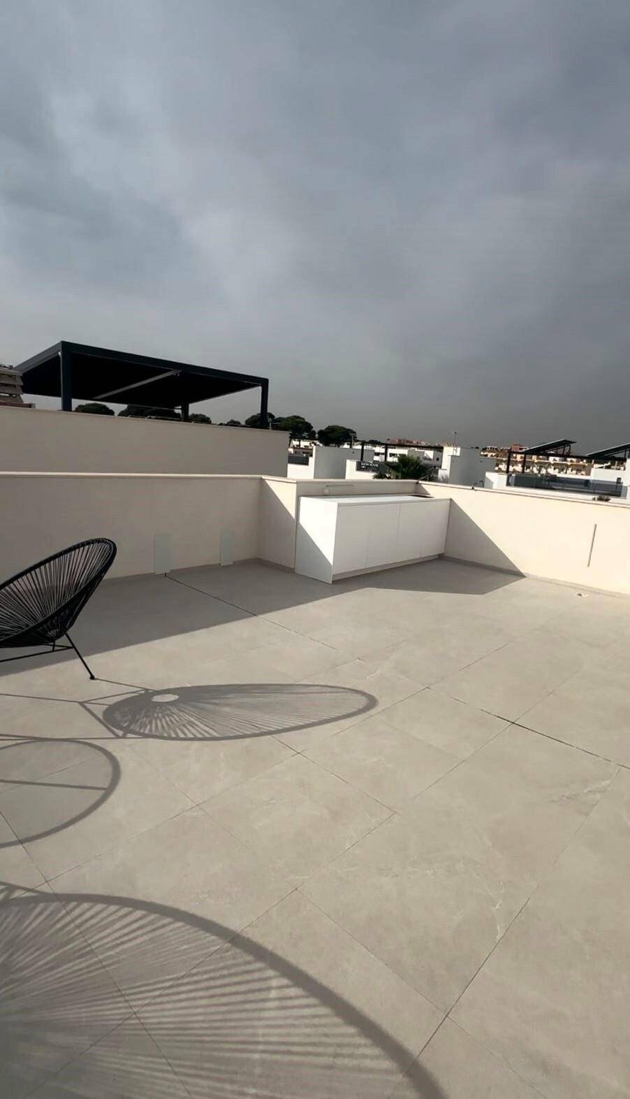 Geräumige Dachterrasse mit Fliesenboden und Blick auf die Umgebung.