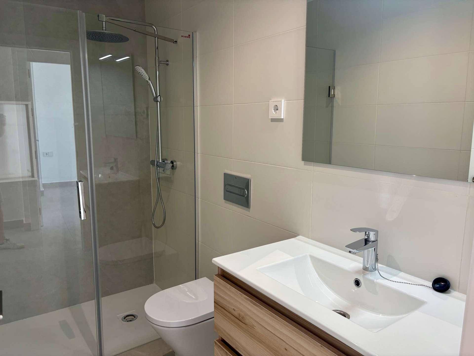 Modernes Badezimmer mit begehbarer Dusche, wandhängendem WC und elegantem Waschtisch.