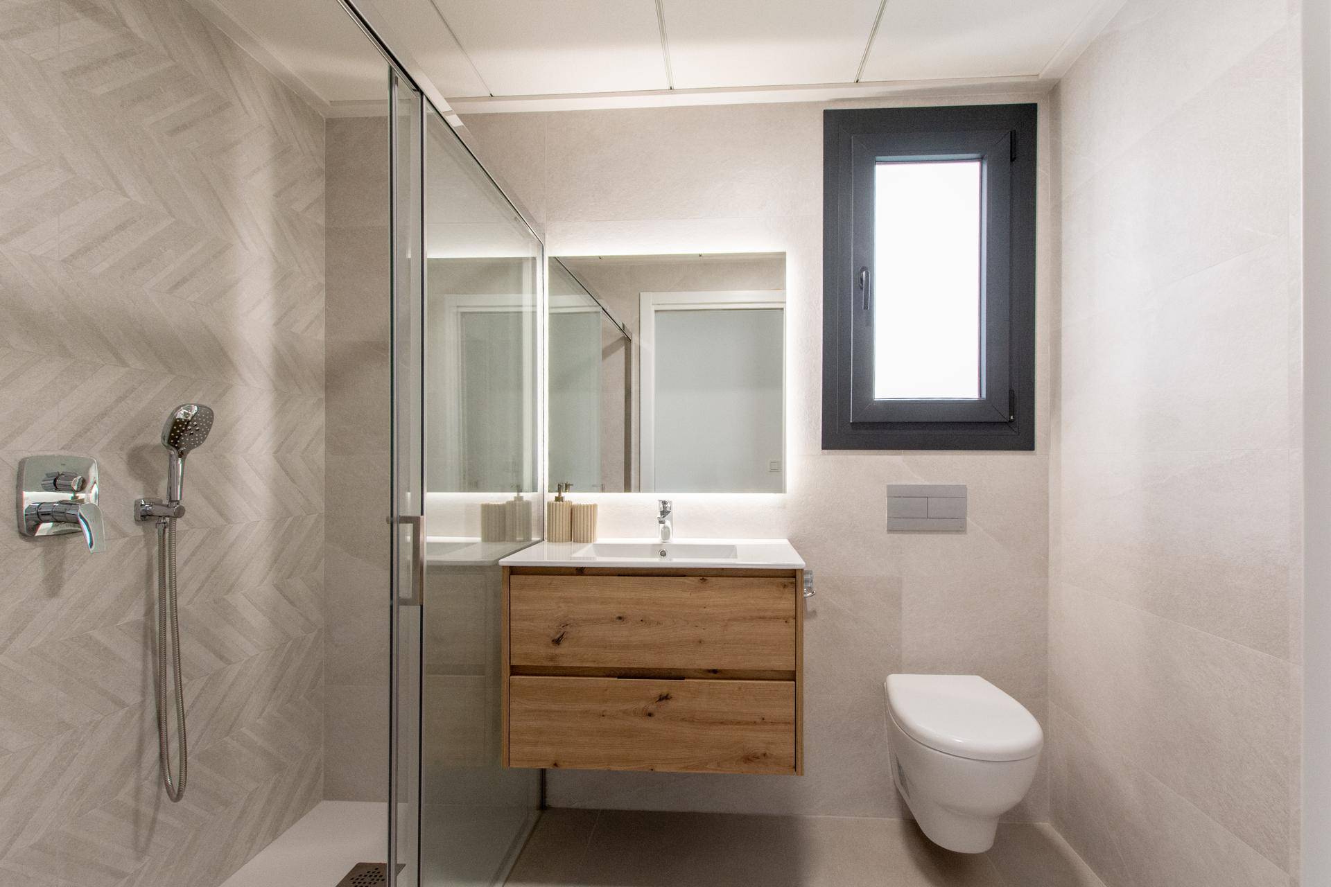 Modernes Badezimmer mit begehbarer Dusche, schwebendem Waschtisch und Fenster.
