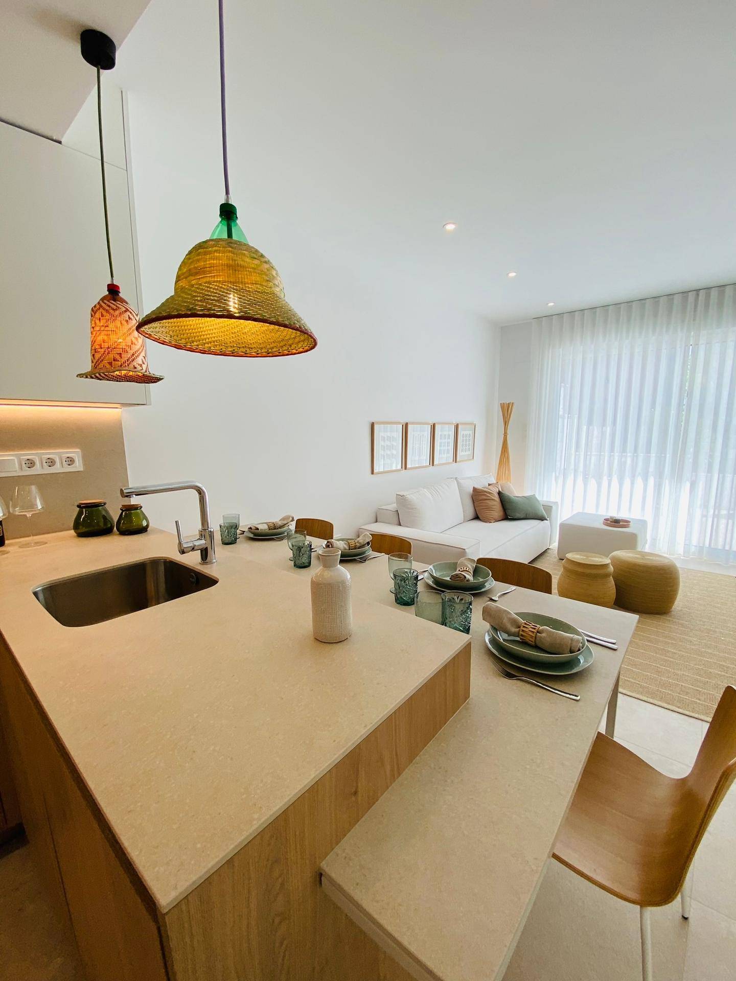 Offene Küche mit integriertem Essbereich an der Insel und Blick auf das Wohnzimmer.