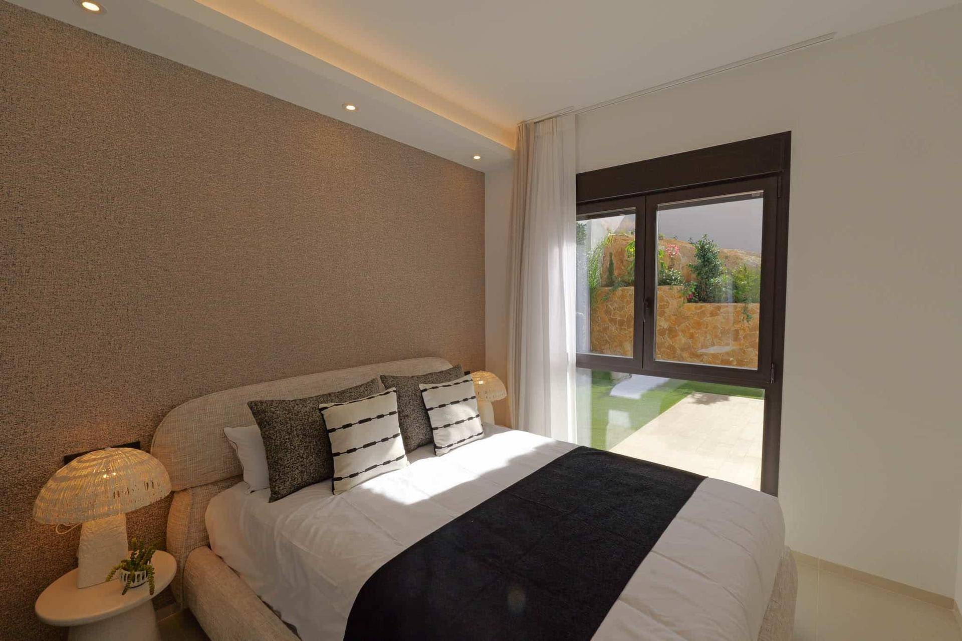 Modernes Schlafzimmer mit großem Fenster und Blick auf den Garten, ideal für erholsame Nächte.