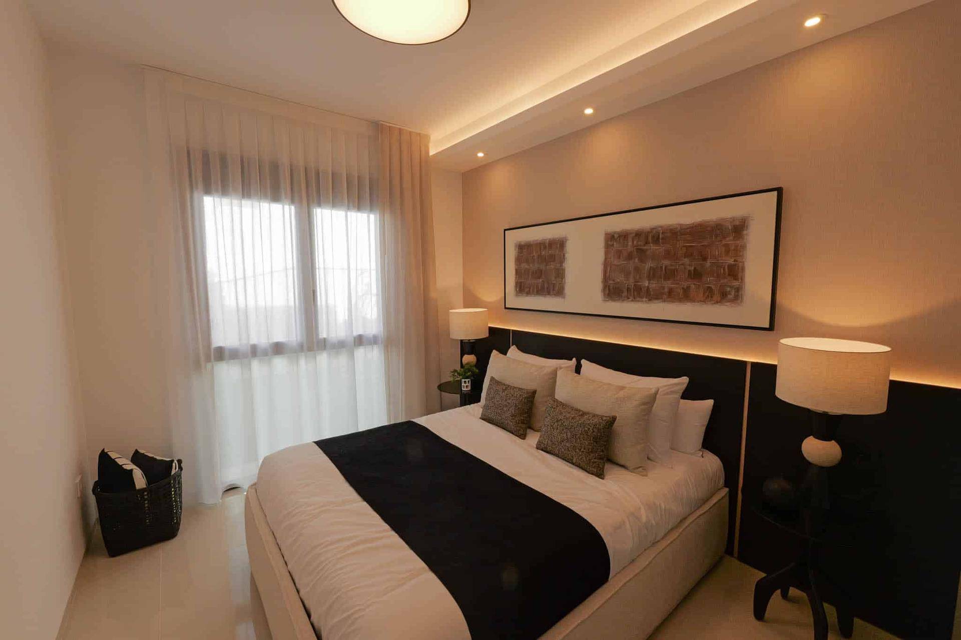 Elegantes Schlafzimmer mit großem Bett, indirekter Beleuchtung und stilvoller Wandgestaltung.