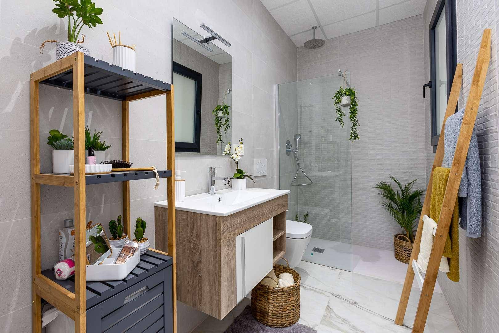 Helles Badezimmer mit modernem Waschtisch, begehbarer Dusche und praktischen Regalen für Utensilien.