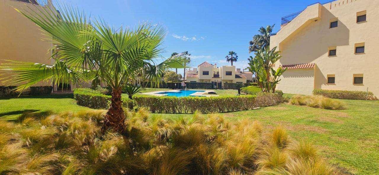 Weitläufige Gartenanlage mit zentralem Pool, umgeben von Hecken und mediterraner Bepflanzung.