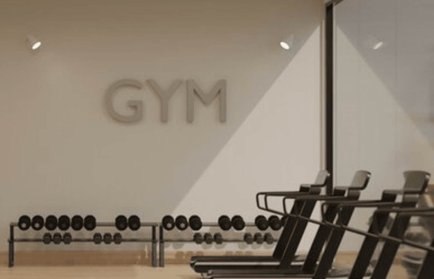 Moderner Fitnessraum mit Laufbändern und Hanteln für das tägliche Training.