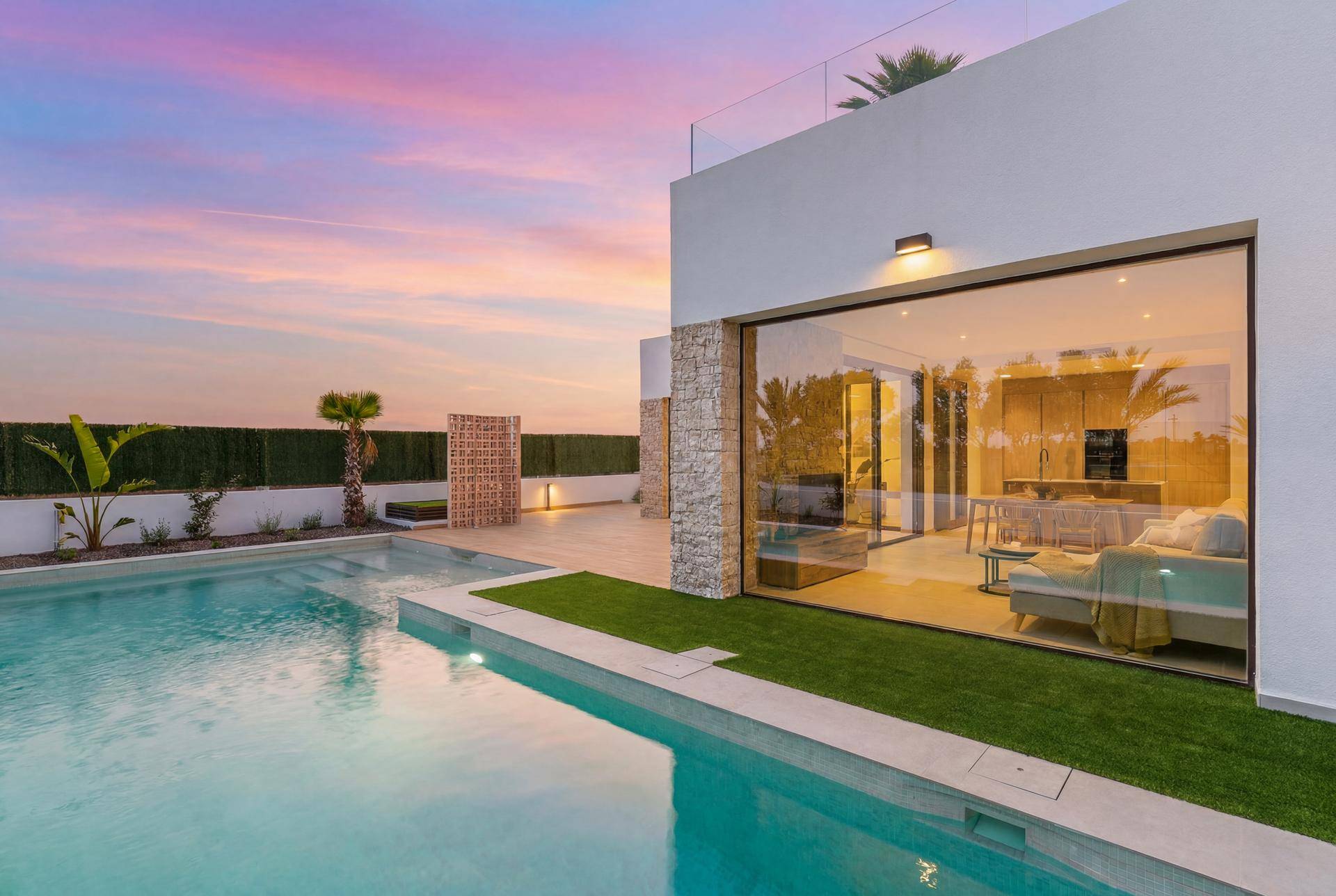 Elegante Villa mit privatem Pool und großen Glasfronten, wunderschön beleuchtet bei Sonnenuntergang.