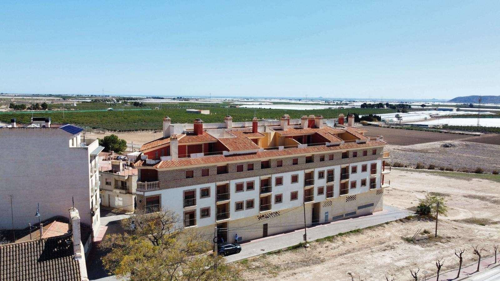 Weitläufige Luftaufnahme eines Wohnkomplexes mit Ziegeldächern und Blick auf die umliegende Landschaft.